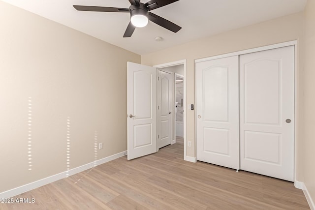 unfurnished bedroom featuring ceiling fan, a closet, and light hardwood / wood-style flooring