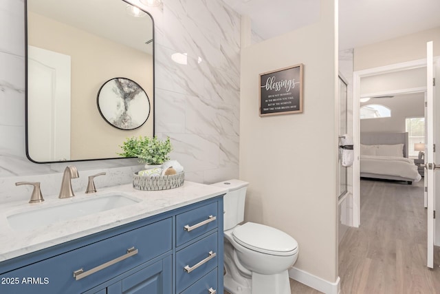 bathroom with hardwood / wood-style floors, toilet, and vanity