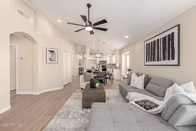 living room with ceiling fan and light hardwood / wood-style flooring