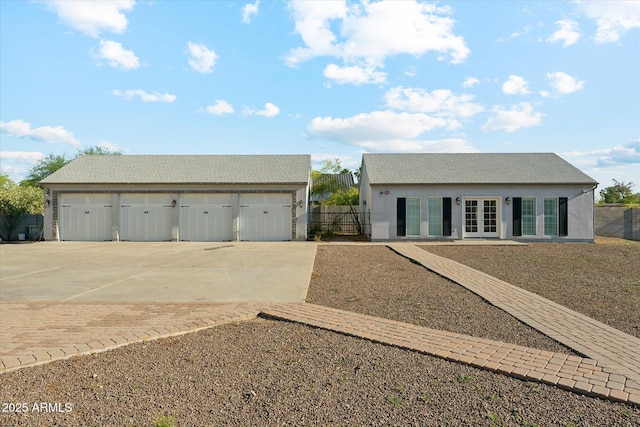 9821 E Larkspur Dr, Scottsdale, AZ 85260 - view of front facade featuring french doors, a detached garage, an outdoor structure, concrete driveway, and stucco siding