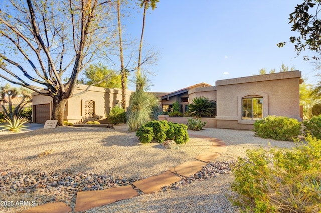 mediterranean / spanish-style home with an attached garage and stucco siding