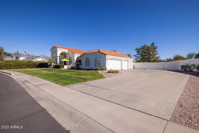 mediterranean / spanish-style house featuring driveway, a tiled roof, fence, a front lawn, and stucco siding