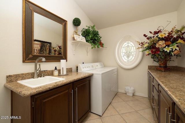 laundry area with cabinet space, light tile patterned floors, baseboards, independent washer and dryer, and a sink