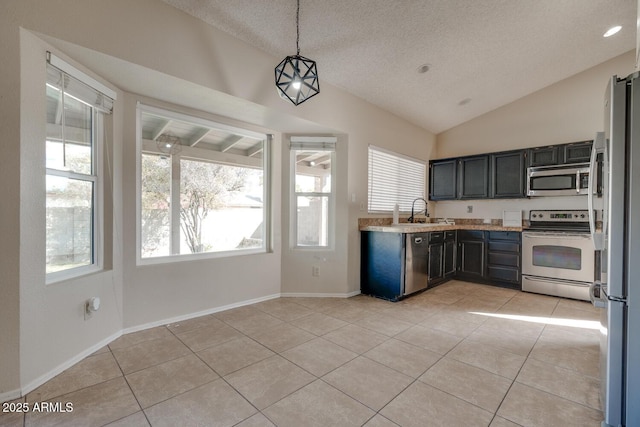 kitchen with light tile patterned flooring, appliances with stainless steel finishes, decorative light fixtures, and a textured ceiling