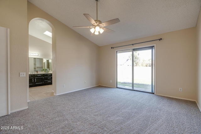 unfurnished room featuring vaulted ceiling, light colored carpet, and ceiling fan