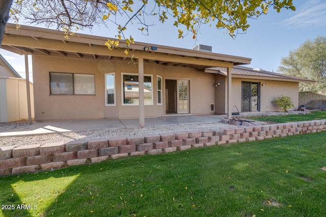 rear view of property featuring a patio and a lawn