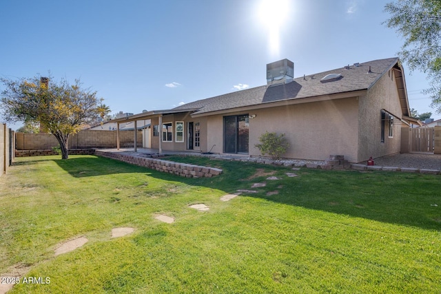 back of property with central air condition unit and a lawn