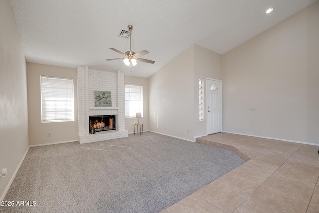 unfurnished living room with ceiling fan, lofted ceiling, light carpet, and a brick fireplace