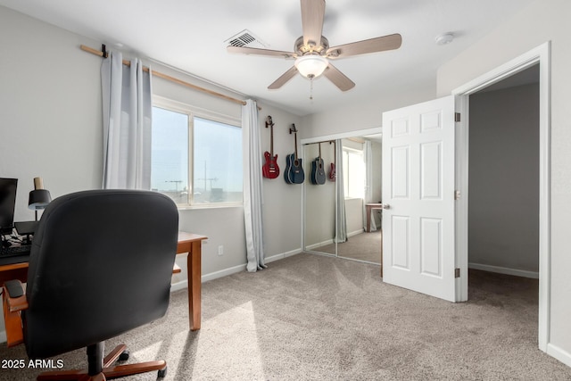 carpeted home office with a ceiling fan, visible vents, and baseboards