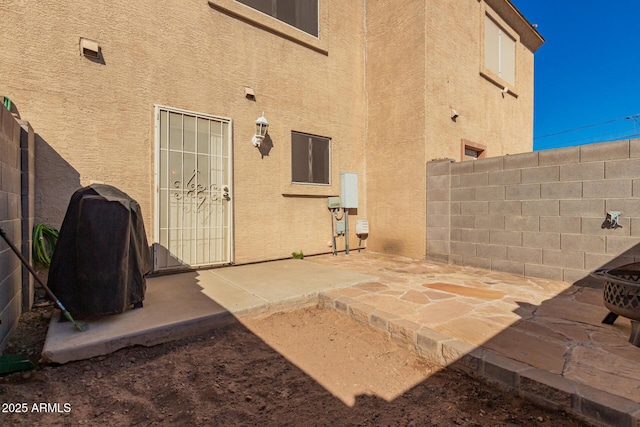 exterior space with a patio area, fence, and stucco siding