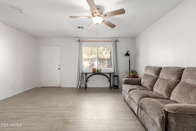 living area with light wood-type flooring, baseboards, visible vents, and a ceiling fan