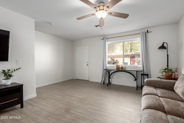 living area with visible vents, ceiling fan, baseboards, and wood finished floors