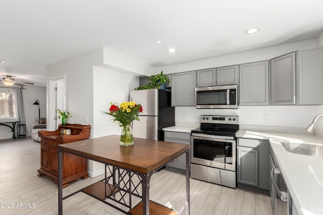 kitchen featuring appliances with stainless steel finishes, wood tiled floor, light countertops, and gray cabinetry