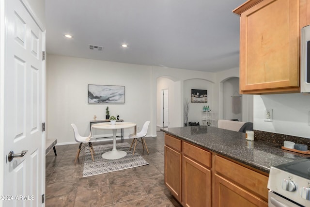 kitchen with white appliances and dark stone counters