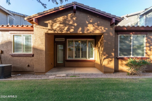 back of house featuring central air condition unit, a yard, and a patio