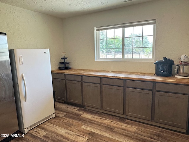 13220 S 154th St, Gilbert, AZ 85296 - kitchen featuring freestanding refrigerator, butcher block countertops, a textured wall, dark wood-style floors, and a textured ceiling