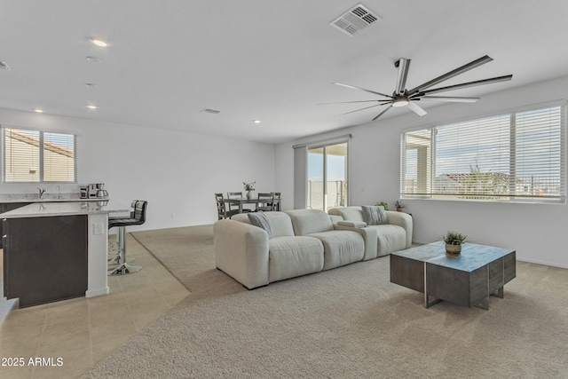 carpeted living room featuring a wealth of natural light and ceiling fan