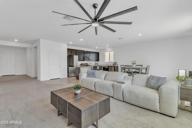 carpeted living room with ceiling fan