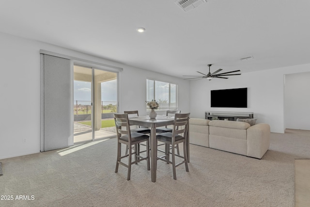 carpeted dining space with ceiling fan