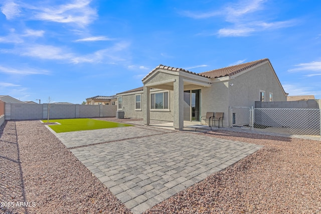 back of house with a patio area, a yard, and central AC