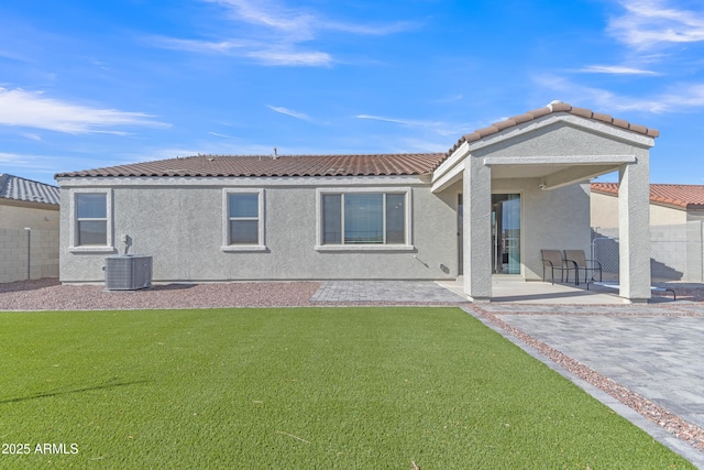 back of property featuring a lawn, a patio area, and central AC