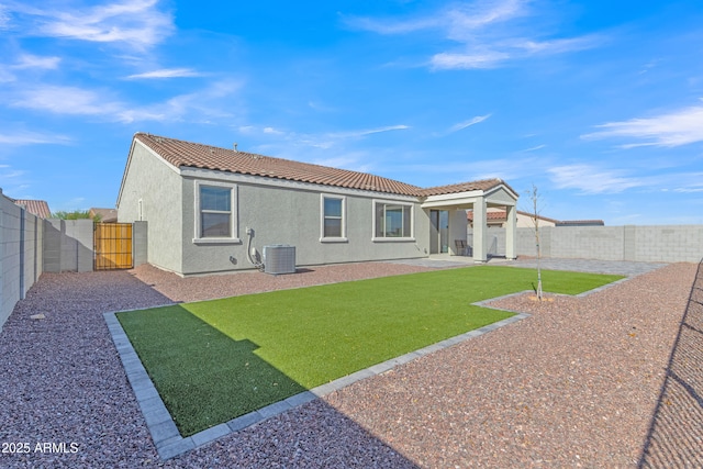 rear view of property featuring a lawn, central air condition unit, and a patio