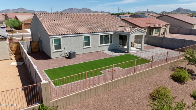 rear view of house with central AC unit, a mountain view, and a patio area