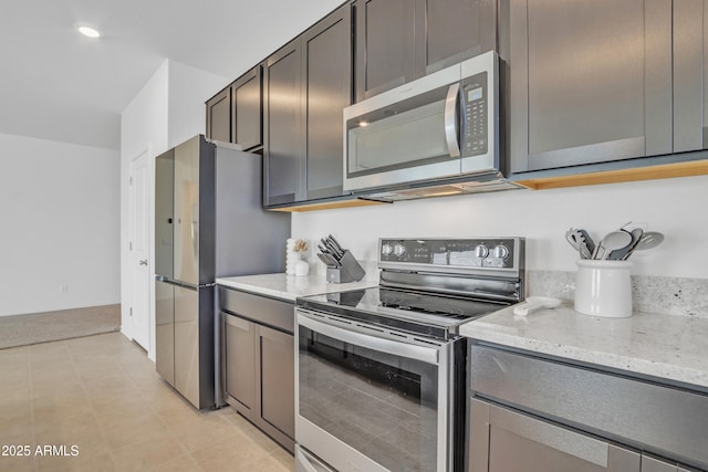 kitchen featuring stainless steel appliances and light stone counters