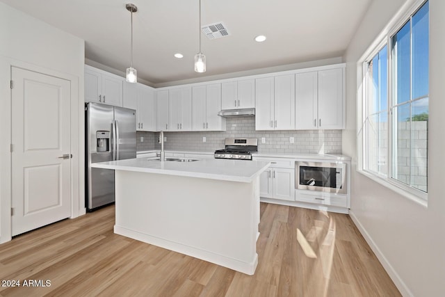 kitchen with white cabinets, stainless steel appliances, a sink, and light countertops