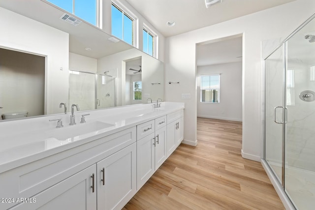 bathroom with vanity, hardwood / wood-style flooring, and a shower with shower door