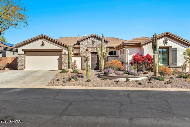 view of front of house with a tile roof, stucco siding, a garage, stone siding, and driveway