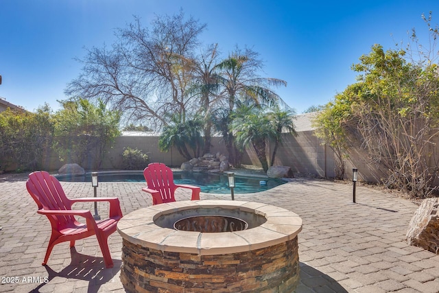 view of patio / terrace featuring a fenced in pool and an outdoor fire pit