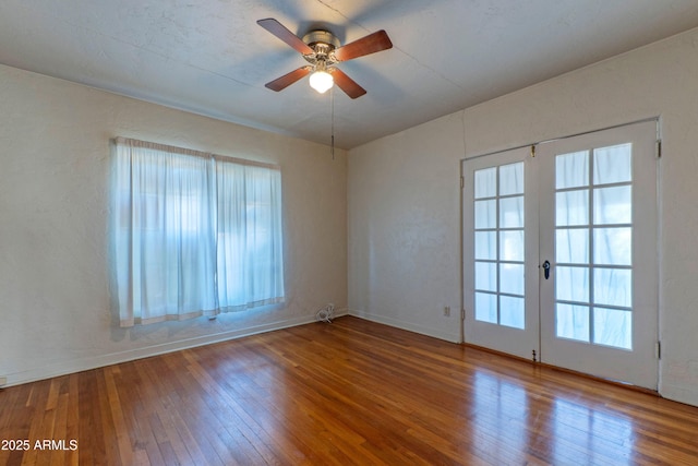 unfurnished room featuring ceiling fan, hardwood / wood-style flooring, french doors, and a healthy amount of sunlight