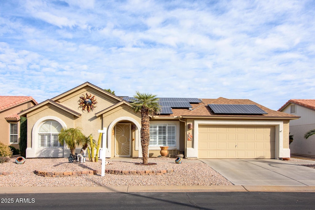 view of front of house featuring a garage and solar panels