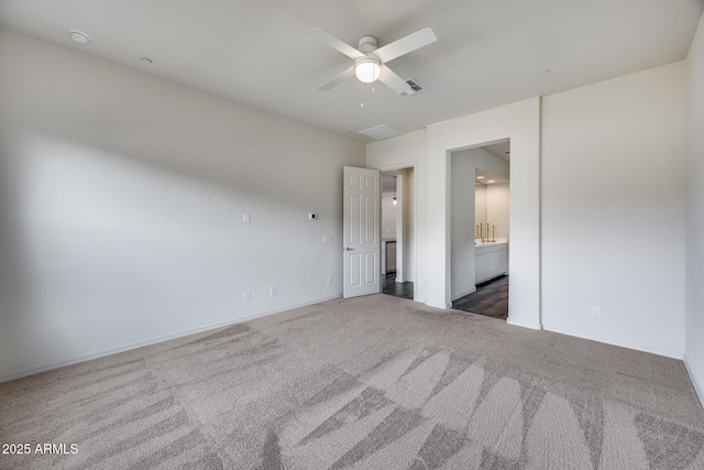 unfurnished bedroom featuring carpet flooring, ensuite bathroom, and ceiling fan