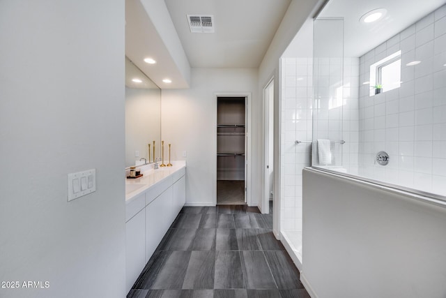 bathroom with visible vents, recessed lighting, a walk in shower, and a walk in closet