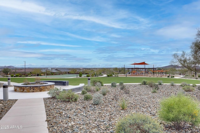 surrounding community with playground community, a lawn, and a mountain view