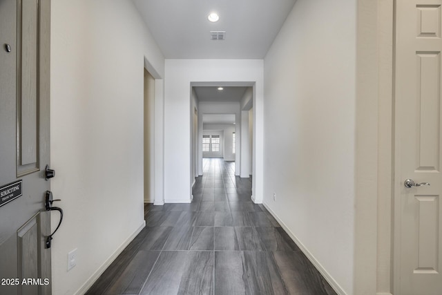 hallway featuring visible vents and baseboards