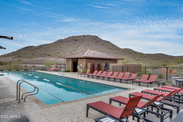 pool featuring a mountain view, a patio, and fence