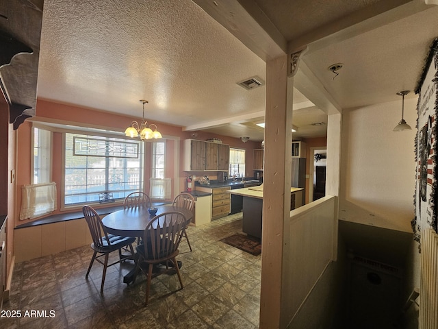 dining space with a textured ceiling, plenty of natural light, and a notable chandelier