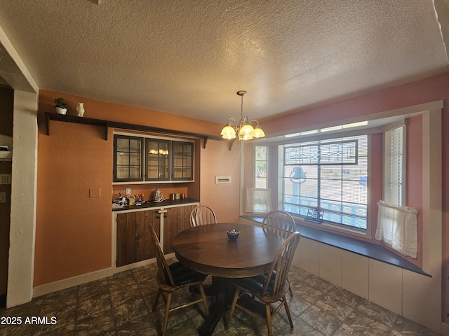 dining space with a chandelier and a textured ceiling