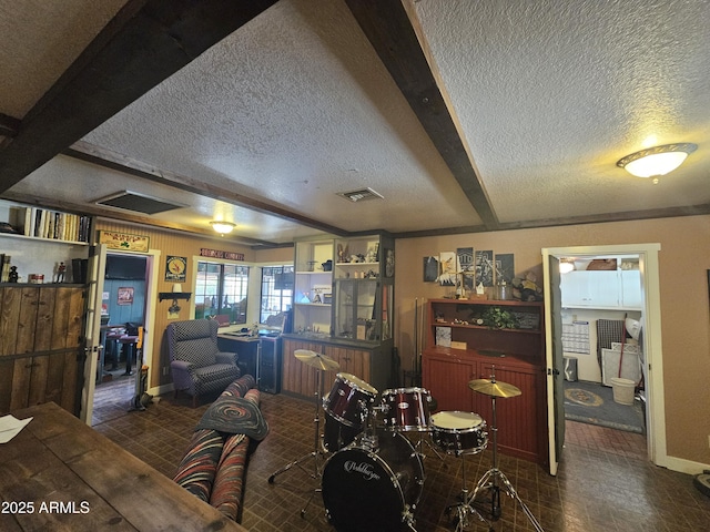 dining space with beam ceiling and a textured ceiling