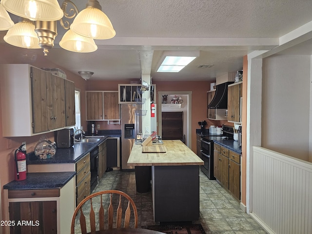 kitchen featuring a textured ceiling, sink, black appliances, a center island, and hanging light fixtures