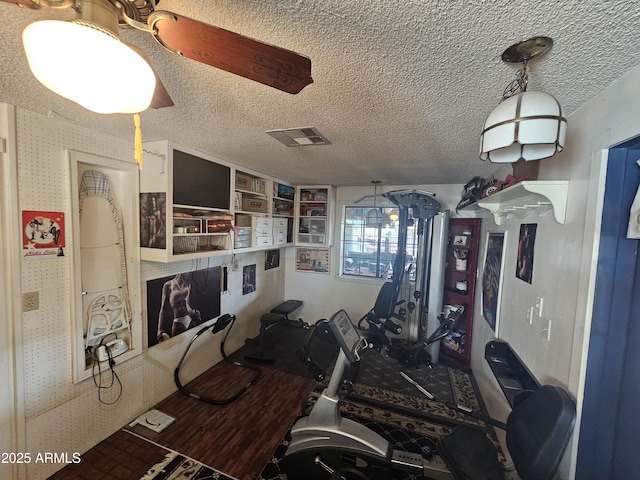 exercise room featuring a textured ceiling