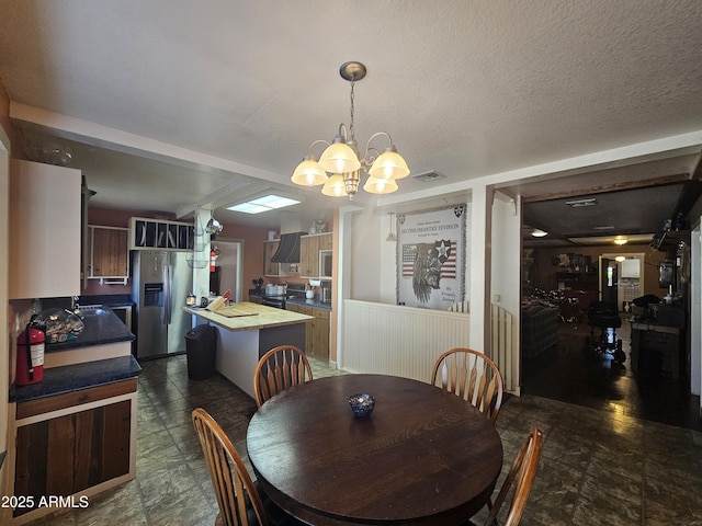 dining room with a chandelier and a textured ceiling