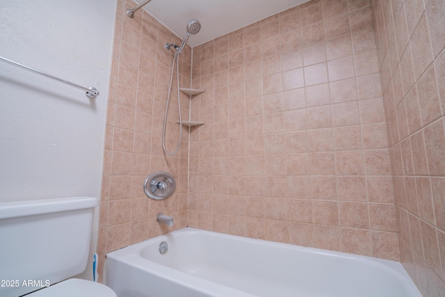 bathroom with toilet and tiled shower / bath