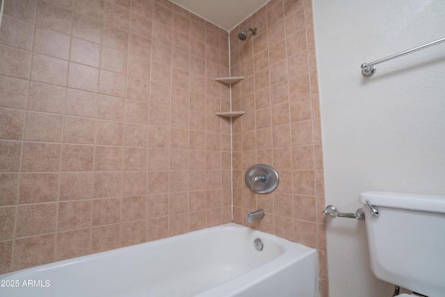 bathroom with toilet and tiled shower / bath combo