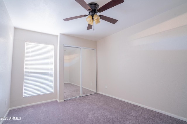 unfurnished bedroom featuring a closet, carpet floors, and ceiling fan