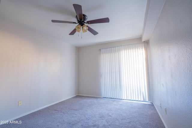 carpeted spare room featuring ceiling fan