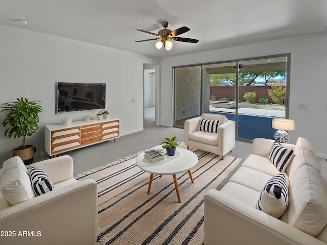 carpeted living room with ceiling fan